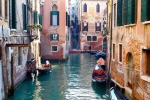 12734262-beautiful-colorful-canal-in-venice-with-parked-gondolas-near-traditional-architecture-italy